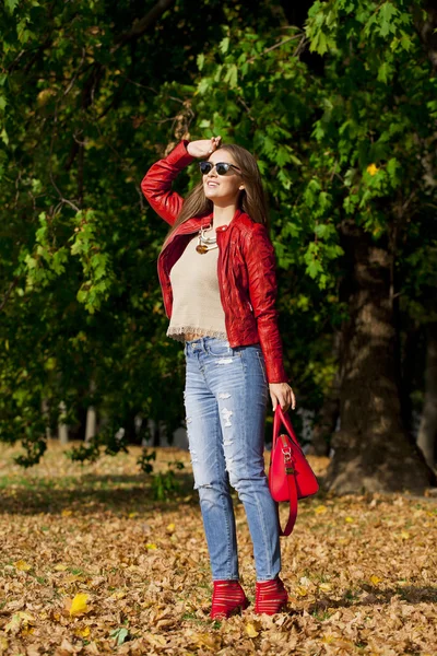 Mladá žena v módní červené bundě a modré džíny v autu — Stock fotografie