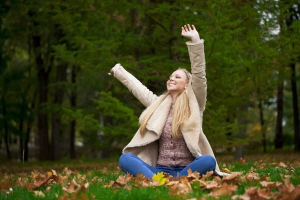 Junge glückliche blonde Frau spaziert im Herbstpark — Stockfoto