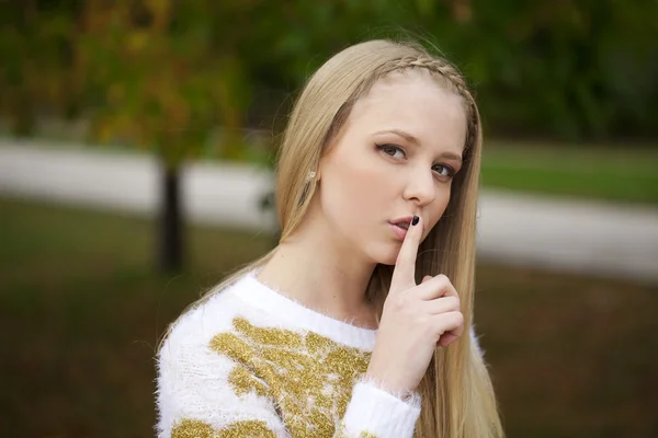 Retrato de atractiva joven rubia con el dedo en los labios — Foto de Stock