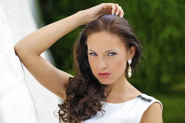 Portrait of beautiful sad girl in white dress leaning on the wal — Stock Photo, Image