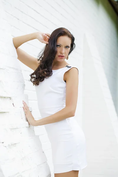 Retrato de bela menina triste em vestido branco inclinando-se sobre o wal — Fotografia de Stock