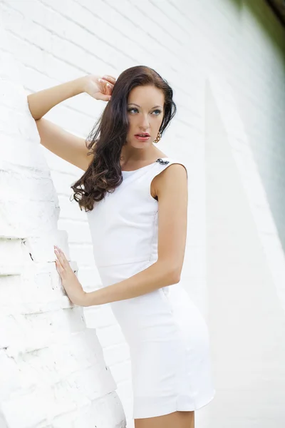 Retrato de bela menina triste em vestido branco inclinando-se sobre o wal — Fotografia de Stock