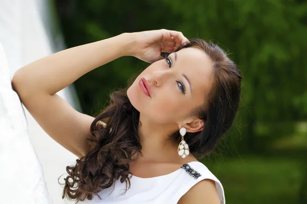 Portrait of beautiful sad girl in white dress leaning on the wal Royalty Free Stock Images