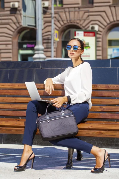 Hermosa mujer de negocios sentada en un banco — Foto de Stock