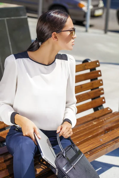 Hermosa mujer de negocios sentada en un banco — Foto de Stock