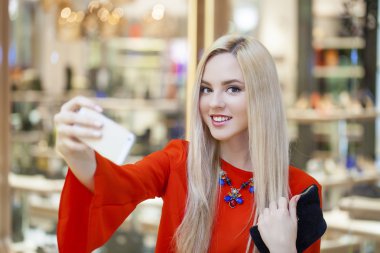 Selfie ile cep telefonu alarak genç güzel sarışın kadın