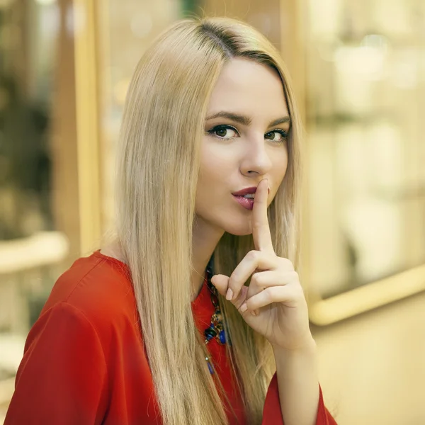 Retrato de atractiva joven rubia con el dedo en los labios — Foto de Stock