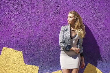 Genç güzel kadın bej kısa elbise açık havada su içinde poz