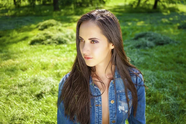 Beautiful young brunette woman in blue jeans jacket — Stock Photo, Image