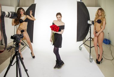 Photoshoot with a bouquet of red roses. Young beautiful women po