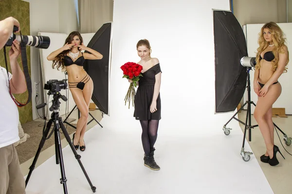 Photoshoot with a bouquet of red roses. Young beautiful women po — Stockfoto