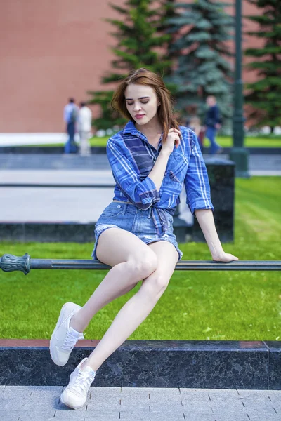 Jovem mulher bonita em uma camisa azul xadrez — Fotografia de Stock