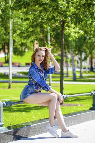 Jonge mooie vrouw in een geruite blauw shirt — Stockfoto