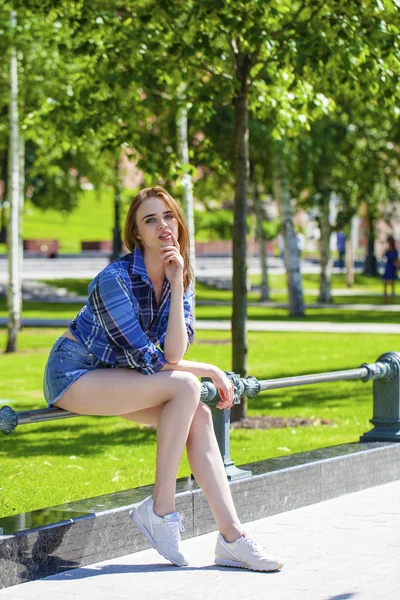 Young beautiful woman in a checkered blue shirt — Stock Photo, Image