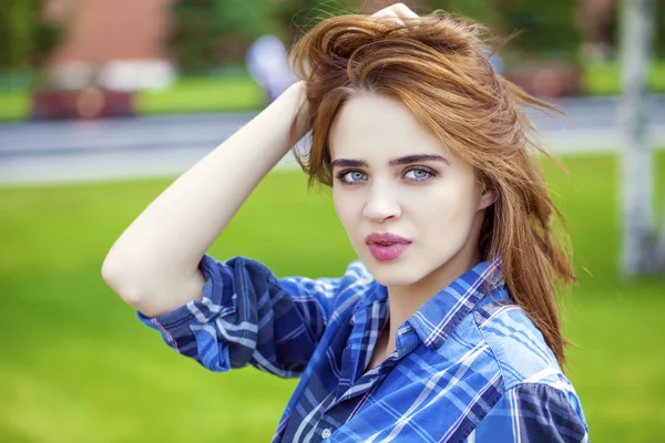 Nahaufnahme einer jungen schönen Frau im karierten blauen Hemd — Stockfoto