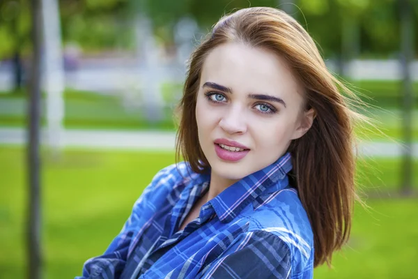 Close up de jovem mulher bonita em uma camisa azul xadrez — Fotografia de Stock