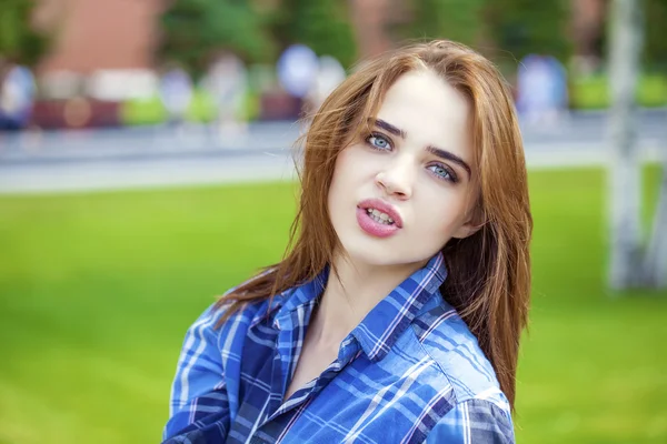 Close up of young beautiful woman in a checkered blue shirt — Stock Photo, Image
