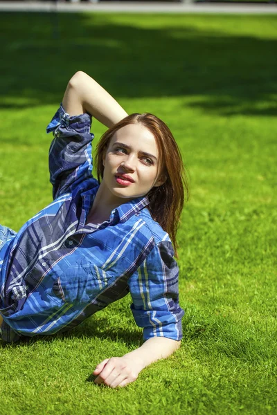 젊은 아름 다운 금발 여자는 잔디에 누워 — 스톡 사진