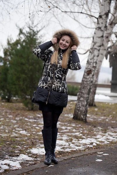 Glada unga blonda kvinnan på bakgrund av en vinter park — Stockfoto