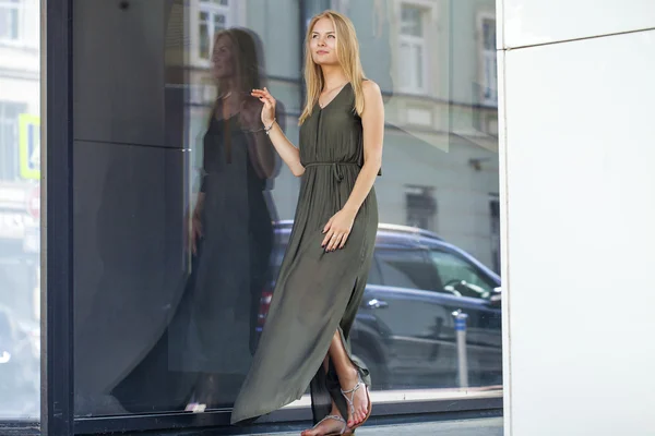 Mladá krásná světlovlasá žena v dlouhé zelené šaty působícím proti — Stock fotografie