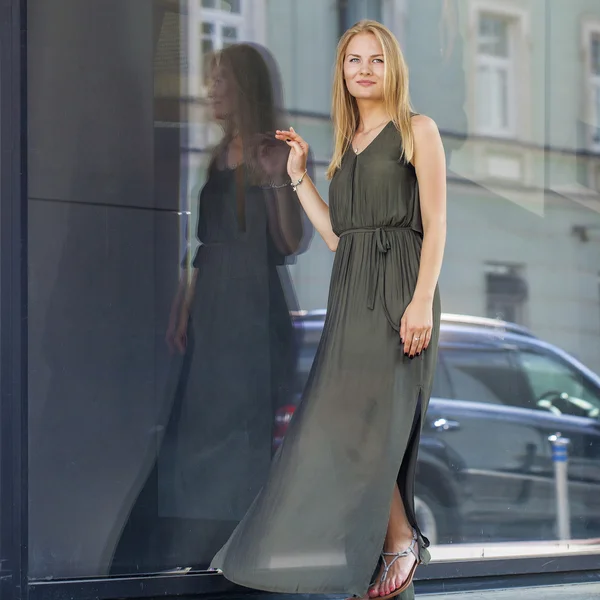 Joven hermosa mujer rubia en vestido verde largo posando contra —  Fotos de Stock