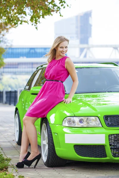 Portrait of a beautiful blonde woman and green sports car — Stock Photo, Image