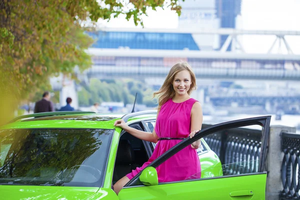 Retrato de una hermosa mujer rubia y coche deportivo verde — Foto de Stock