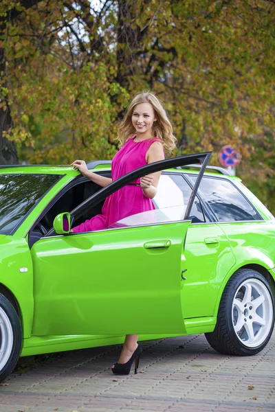Portrait of a beautiful blonde woman and green sports car — Stock Image Portrait of a beautiful blonde woman and green sports car Royalty Free Stock Images