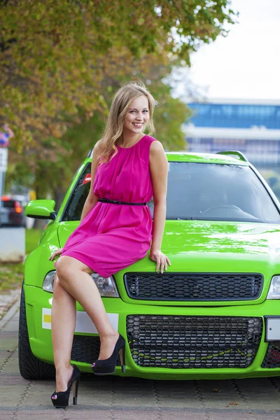 Portrait of a beautiful blonde woman and green sports car — Stock Image Portrait of a beautiful blonde woman and green sports car Royalty Free Stock Photos