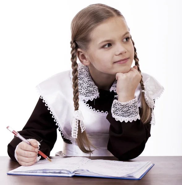 Jonge mooie schoolmeisje zitten aan een bureau — Stockfoto