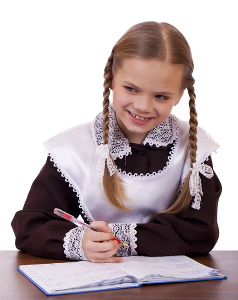 Jonge mooie schoolmeisje zitten aan een bureau — Stockfoto