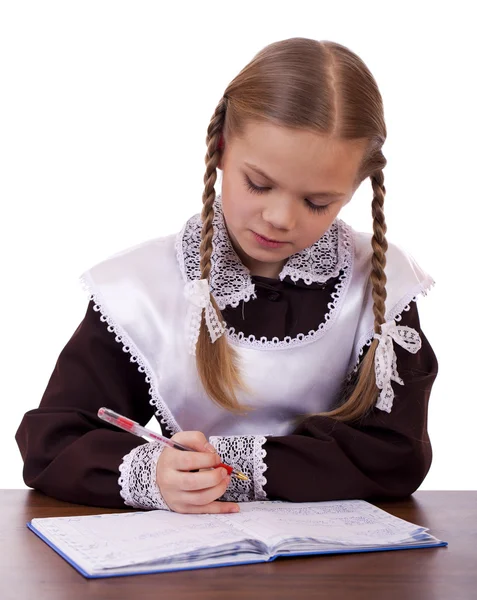 Jonge mooie schoolmeisje zitten aan een bureau — Stockfoto