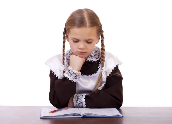 Jonge mooie schoolmeisje zitten aan een bureau — Stockfoto