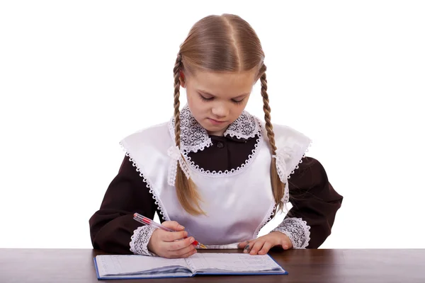 Jonge mooie schoolmeisje zitten aan een bureau — Stockfoto