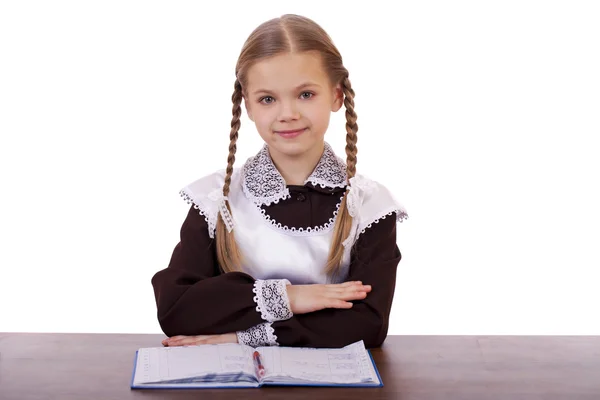 Jonge mooie schoolmeisje zitten aan een bureau — Stockfoto