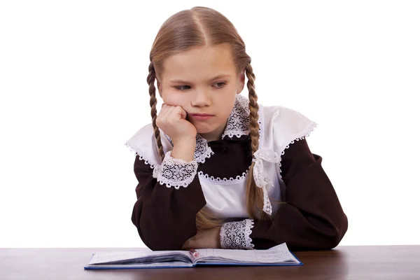 Sad schoolgirl sits at a school desk — Stock Photo, Image