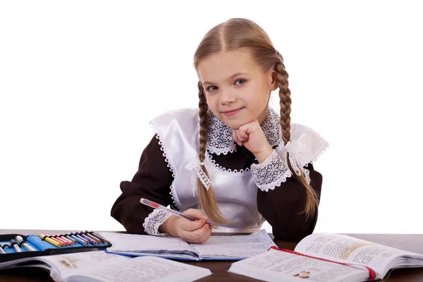 Jonge mooie schoolmeisje zitten aan een bureau — Stockfoto