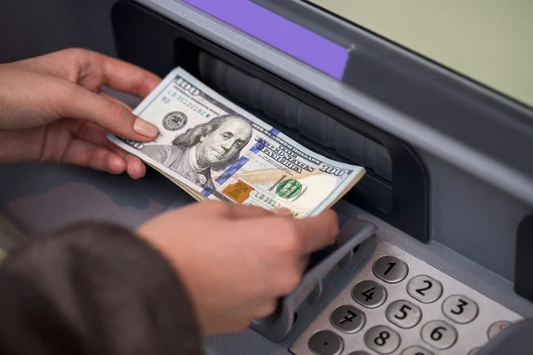 Mão de mulher mostrando notas de dólar na frente do caixa eletrônico — Fotografia de Stock