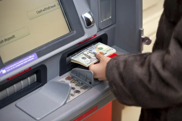 Γυναίκα χέρι δείχνοντας Δολάριο τραπεζογραμμάτια μπροστά από το ΑΤΜ — Φωτογραφία Αρχείου