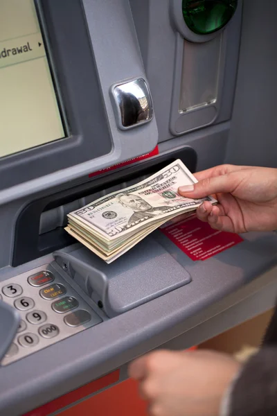 Mano de mujer mostrando billetes de dólar frente al cajero automático — Foto de Stock