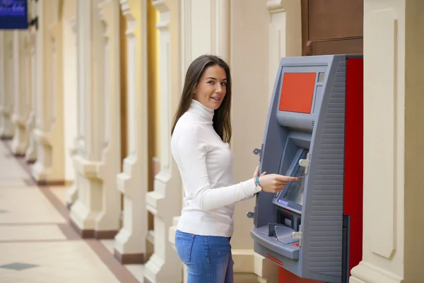 Jonge vrouw opnemen van geld van credit card bij atm — Stockfoto