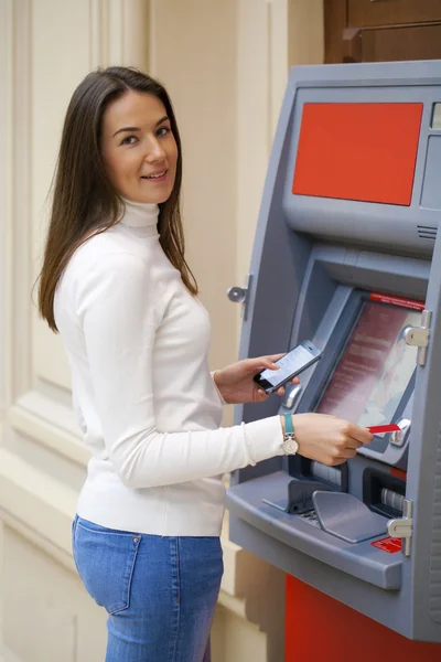 Młoda kobieta Wypłacanie pieniędzy z karty kredytowej w bankomacie — Zdjęcie stockowe