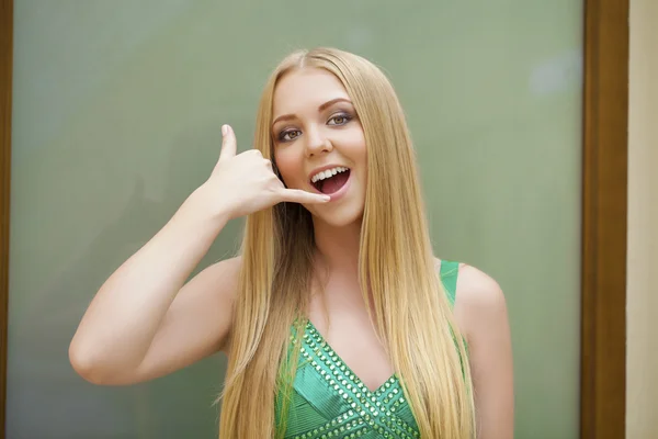 Llámame. Sexy mujer joven en vestido verde haciendo una llamada me gestur — Foto de Stock