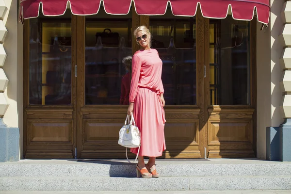 Mooie vrouw in roze jurk in de winkel — Stockfoto