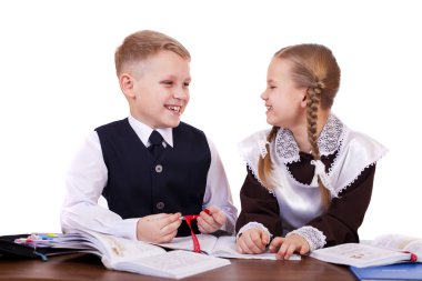 İlköğretim okulu öğrencileri birkaç masa başında oturmak