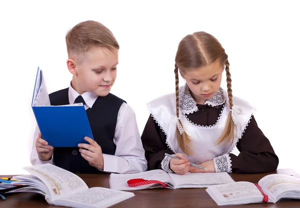 Un par de estudiantes de primaria se sientan en un escritorio —  Fotos de Stock