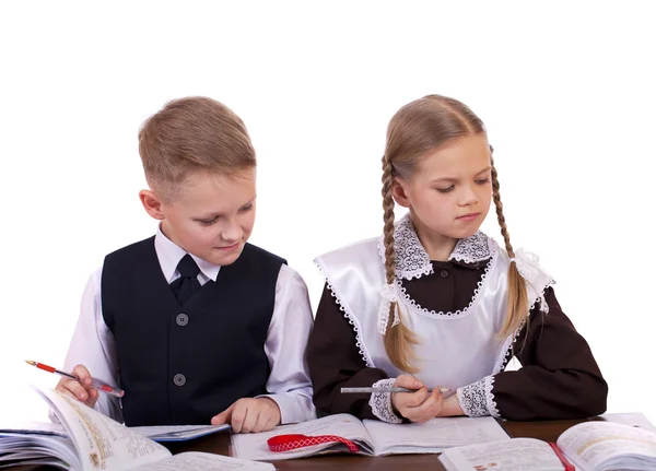 Een paar van elementary schoolstudenten zitten aan een bureau — Stockfoto