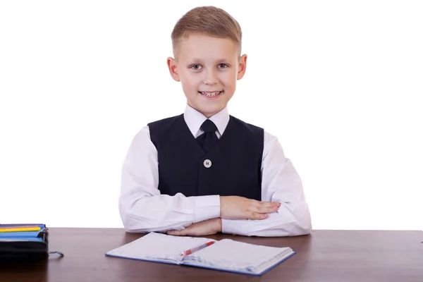 Kaukasiska skola pojke vid sitt skrivbord på vit bakgrund med kopia s — Stockfoto