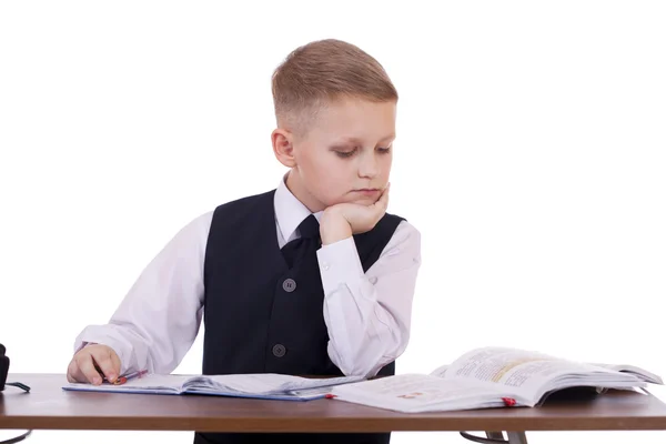 Kaukasiska skola pojke vid sitt skrivbord på vit bakgrund med kopia s — Stockfoto