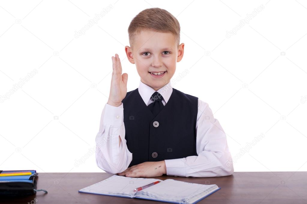 Caucasian school boy at his desk on white background with copy s